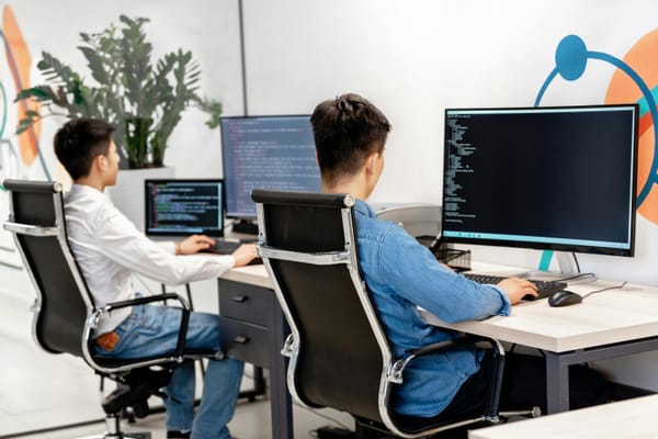 Two coders working on their desktop.