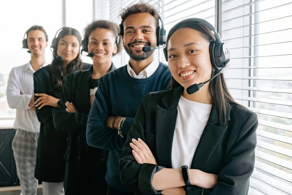A group of staff smiling with headphones and microphone.